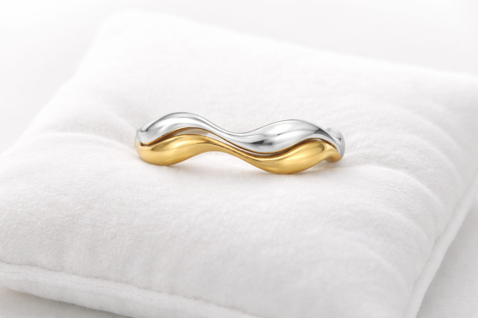 Gold and silver ring on a white cushion
